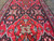 Red and black tribal medallions viewed lengthwise showing ivory, salmon and emerald wool accents