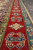 Red main border close-up with ivory diamond rosettes, navy hooks and sky blue guard band