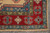 Corner detail with red border, blue end panel, olive minor border and hand-tied fringe