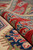 Rolled edge showing thick wool pile depth, dense knotting and hand-wrapped ivory selvage