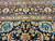 Close-up of navy main border with ivory rosettes, scrolling vines and paired sky blue guard bands