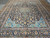 10x13 Persian Kashan rug angled from one end, navy field, blue spandrels and wide floral border
