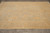 8 x 10 Peshawar wool rug photographed flat on grey tile floor in daylight