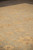 Angled view across the pale green field showing golden palmettes and subtle hand-spun wool striation