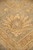 Macro of a beige palmette outlined in rust against the soft green border ground