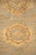 Soft focus detail of a honey gold rosette floating on the muted grey green ground