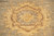 Detail of a cream and gold blossom against light sage green hand-spun wool pile