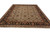 Angled floor view showing hand-knotted wool pile and black palmette border on green Indian rug