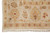 Corner detail of the rose-tan main border framing gold lotus palmettes and red accents