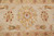 Macro of a central palmette motif in gold, sage and rust against beige ground