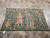 4 by 6 antique tapestry on tile floor with inventory rug tag visible at corner