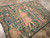 Angled view of the flat weave tapestry highlighting fine wool detail in robes, leaves and lettering