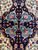 Macro of four mirrored blue cartouches holding salmon blossoms on deep indigo medallion ground