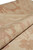 Macro of the folded edge showing dense knotting, soft wool nap and pale salmon border motifs