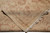 Folded corner revealing low wool pile, cotton foundation weave and hand-tied ivory fringe on this Turkish rug