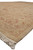 Corner of the beige Oushak rug at floor level, showing border layering, selvage and fringe