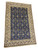 Angled full view of 4x6 wool and silk Nain rug showing ivory border and navy field