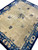 9 x 12 antique Chinese Peking rug photographed at an angle showing wide blue floral border