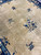 Champagne field close-up with small blue vases and peony sprays, soft antique wool sheen visible