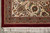Corner detail with ruby red outer band, ivory border rosettes and hand-tied cream cotton fringe