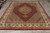Hand-knotted Tabriz Mahi rug laid flat with ivory fringe, ruby field and olive green spandrels