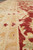Low angle across the beige border into the red field, showing wool sheen and vines