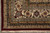 Corner view with ivory palmette border, burgundy outer stripe and white cotton fringe on tile