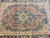 Close view of the 10 point star medallion in navy and camel on rust ground
