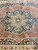 Detail of central rosette, camel medallion field and indigo floral surround in fine antique weaving