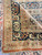 Folded corner revealing the tight hand-knotted back, low wool pile and straight selvage of this antique rug