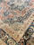 Corner detail of navy palmette main border, ivory guard stripes and floral spandrel on rust field