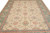 Close overhead of the ivory field with coral rosettes, soft teal leaves and blue outer border