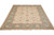 Angled view of hand-knotted wool Ziegler area rug, cream field framed by wide green border