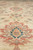 Field close-up of large coral palmettes with blue centers on a sandy beige wool ground