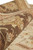Rolled edge close-up showing wool pile depth, chocolate border leaves and cream ground beneath