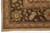 Border corner detail with olive palmettes, rust scrollwork and ivory fringe over dark brown ground