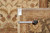 Back tag reading genuine hand woven Oriental rug 10274 beside a tape measure on pile
