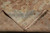 Folded corner revealing the even hand-knotted back, cotton foundation and ivory fringe of the rug