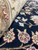 Rolled edge showing thick wool pile, silk sheen and beige border flowers outlined in burgundy