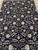 Close view of the black field with rose, ivory and gold blossoms on scrolling vines