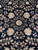 Mirrored floral sprays and a small ivory rosette centered on the deep black wool pile