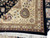Folded corner revealing beige spandrel, burgundy guard border and hand-tied ivory fringe in perfect condition