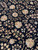 Dense all-over floral pattern of roses, rosettes and leafy vines across the black ground