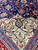 Ivory spandrel corner with red arabesque scrolls meeting the deep navy field and blue guard