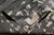 Folded corner revealing the tight hand-knotted back and even knot structure behind the gray ivory abstract design