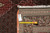 Back of the 6'8" x 10' Tabriz rug with measuring tape and handwritten inventory tag