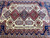 Center field of the 9'10" x 13'6" Kazak rug showing triple medallion layout in rust and blue