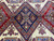 Close-up of the navy central medallion with latch hook arms and rust flanking lozenges