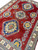 Angled view of triple medallion layout across deep red field with gold octagon cartouches
