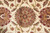 Detailed macro of a multicolored 8 petal rosette on warm beige wool pile